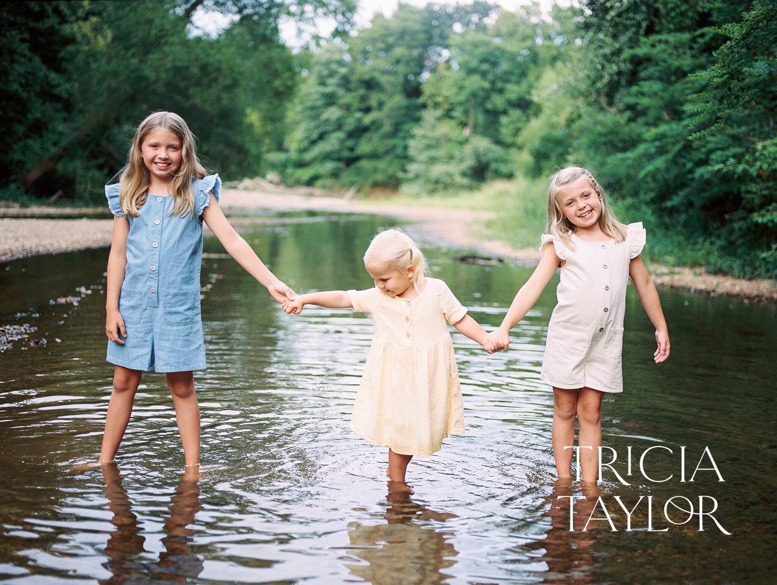 Three sisters walk through a creek in dresses holding hands Things to do in paducah